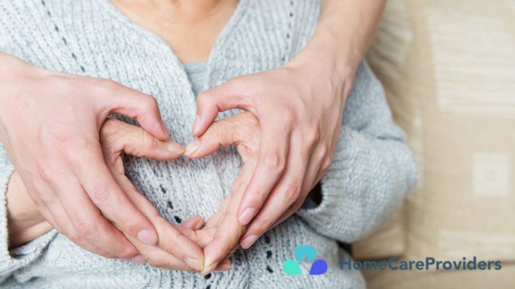 Hands of a caregiver and an elderly person forming a heart shape