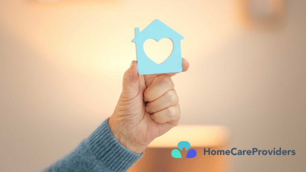 A hand holding a blue house-shaped cutout with a heart in the center