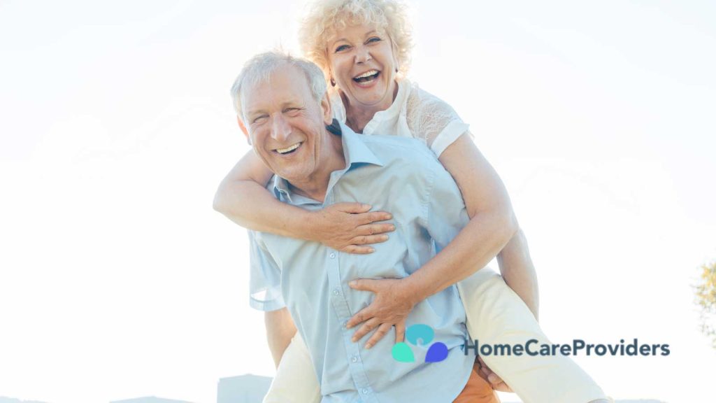 A joyful elderly couple is enjoying a piggyback ride outdoors