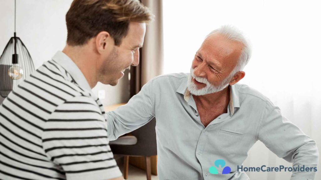 An elderly man having a conversation with his caregiver