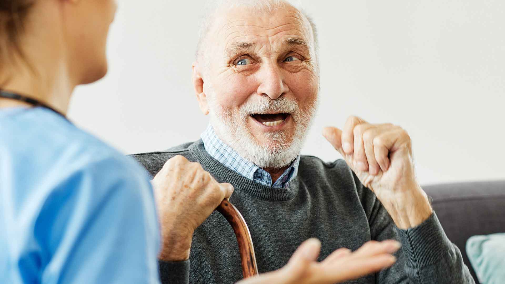 An elderly man having a conversation with a nurse at home